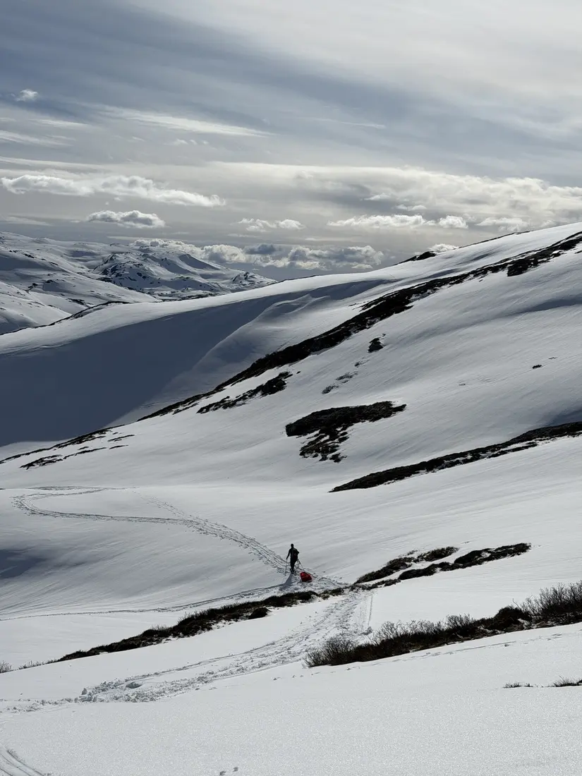 Person bærer forsyninger i fjellterreng